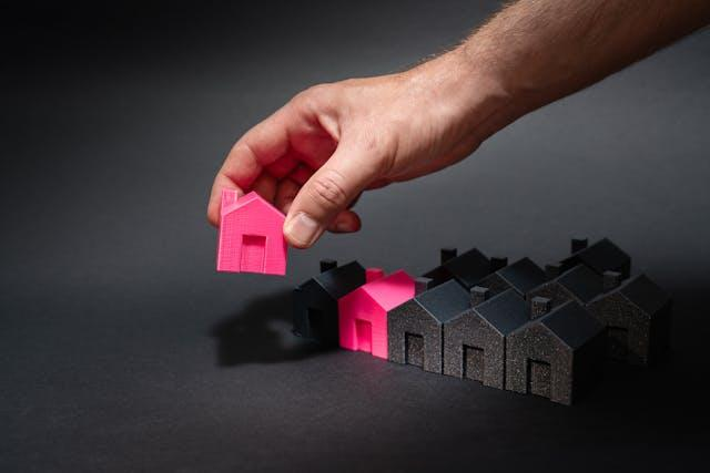 A person lining up small house figurines